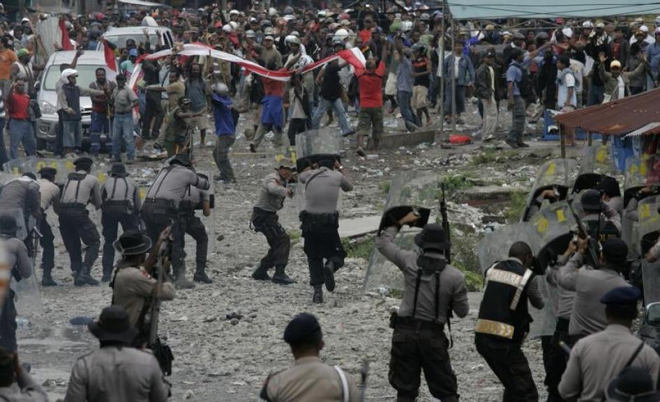 Police fire warning shots in the air to disperse protesters during a demonstration in Timika of Indonesia's Papua province October 10, 2011.