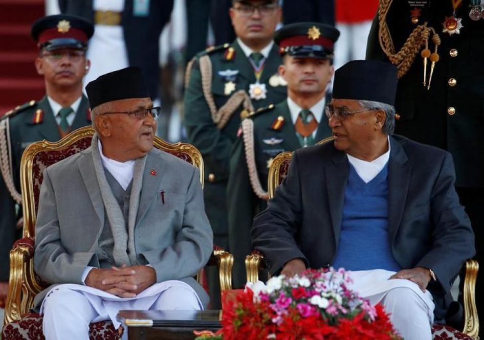 Newly elected Nepalese Prime Minister Khadga Prasad Sharma Oli, also known as K.P. Oli (L), speaks with the outgoing Prime Minister Sher Bahadur Deuba, after administrating the oath of office at the presidential building "Shital Niwas" in Kathmandu, Nepal