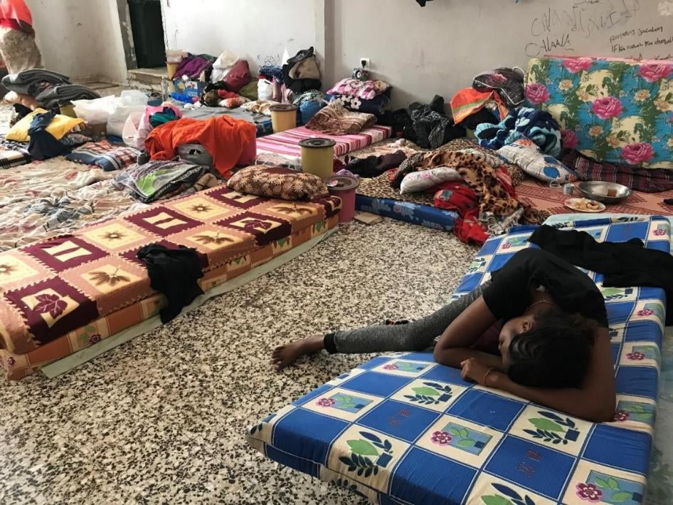 Une migrante épuisée se repose sur un matelas dans le centre de détention de Tajoura à Tripoli, en Libye, le 8 juillet 2018. 
