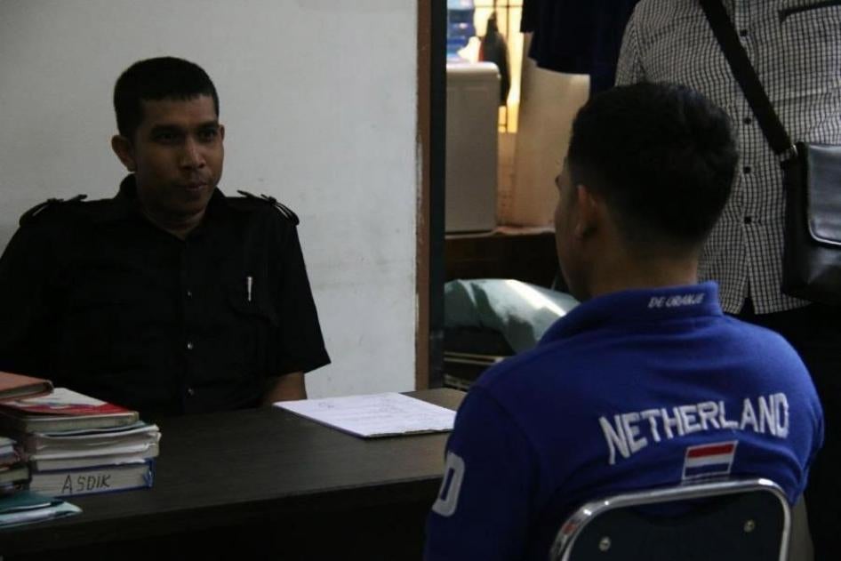 On March 29, 2018, vigilantes forcibly entered a private house in Aceh province and called the Sharia (Islamic law) police, who arrested two male college students for allegedly having sex. A police officer questions one of the men in the Sharia