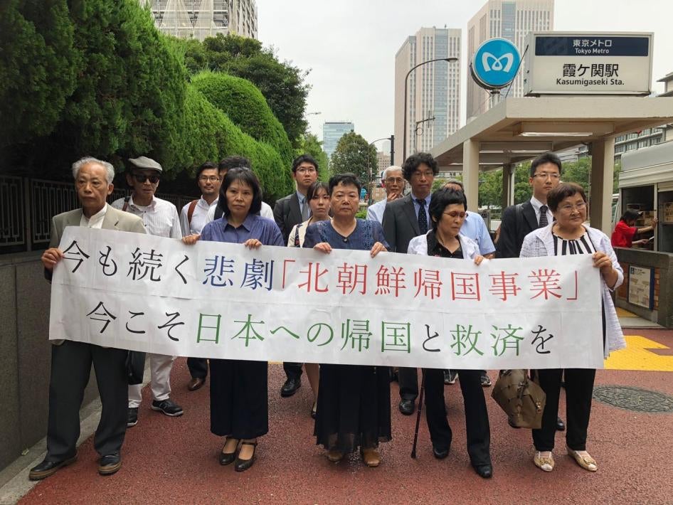 朝鲜“人间天堂”案的五位原告手持横幅，支持者站在他们身后，东京，2018年8月19日。