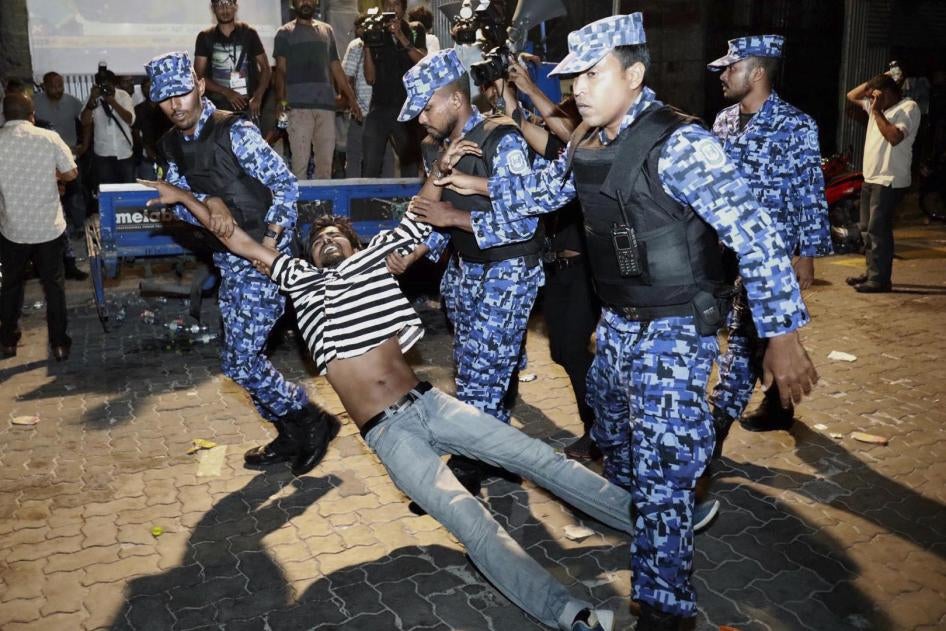 عناصر من الشرطة يعتقلون متظاهرا من المعارضة يطالب بإطلاق سراح السجناء السياسيين أثناء مظاهرة في مالي، المالديف، 2 فبراير/شباط 2018.