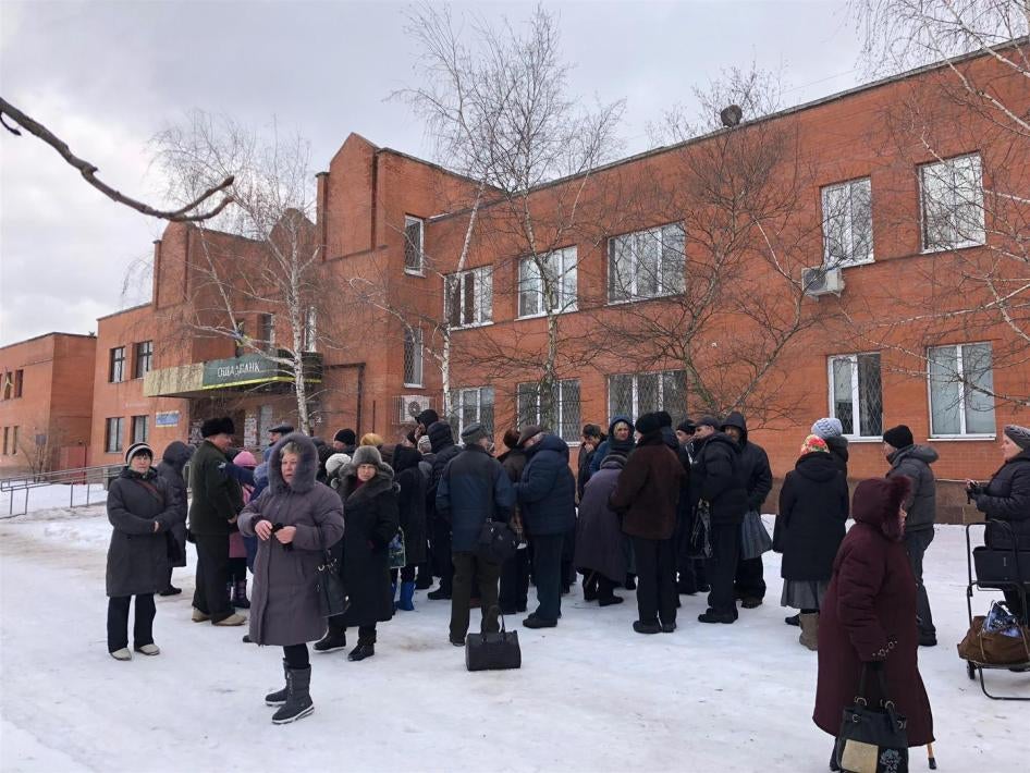 Пенсіонери стоять у черзі перед відділенням державного банку у підконтрольній уряду Станиці Луганській.