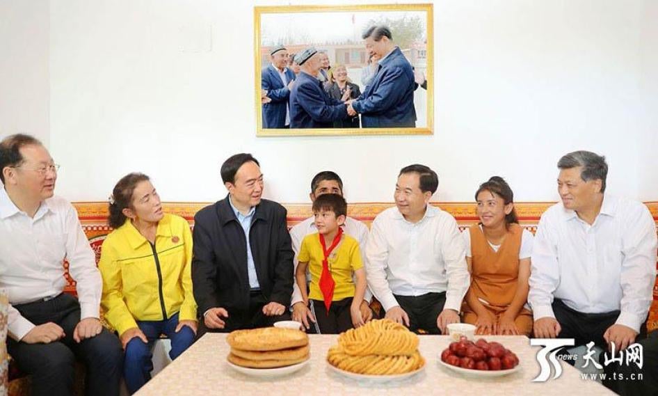 Xinjiang Party Secretary Chen Quanguo (third from left) in a state press photo visiting a Turkic Muslim family in Xinjiang. 