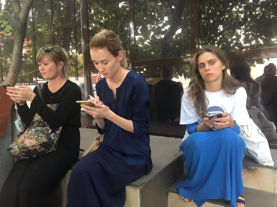 Journalists and human rights defends wait on the doorstep of a Chechnyan court building after the judge closed the hearings for human rights defender Oyub Titiev to the public.