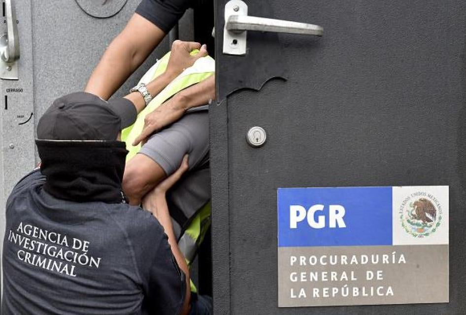 Agentes especiales de la Procuraduría General de la República suben a un vehículo blindado a algunos de los 27 policías municipales presuntamente implicados en un ataque perpetrado contra estudiantes en Iguala hace un mes.