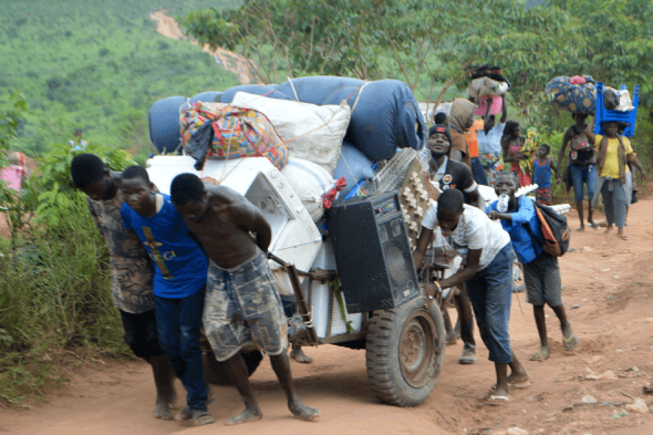 Des migrants congolais qui vivaient en Angola transportent quelques biens près de la ville frontalière de Kamako, en RD Congo, le 12 octobre 2018, après être rentrés dans leur pays à la suite de mesures de répression prises au nom de la sécurité par les a