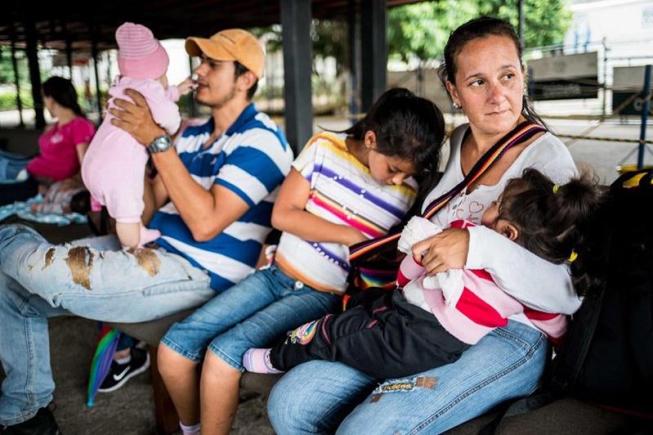 Des Vénézuéliens ayant traversé la frontière avec la Colombie attendent avec leurs enfants dans un centre de vaccination géré par l'Organisation panaméricaine de la santé, situé en Colombie près de la frontière, le 28 juillet 2018. 