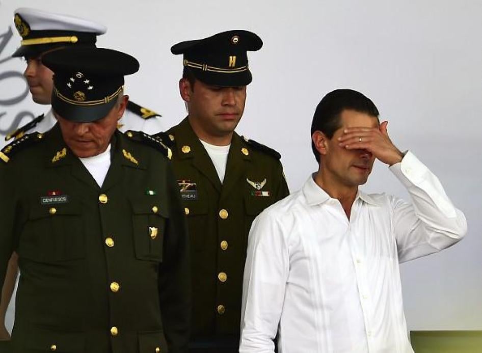 Mexican President Enrique Pena Nieto (R) gestures during an event for the National Flag Day in Iguala, Guerrero State, Mexico on February 24, 2016. 