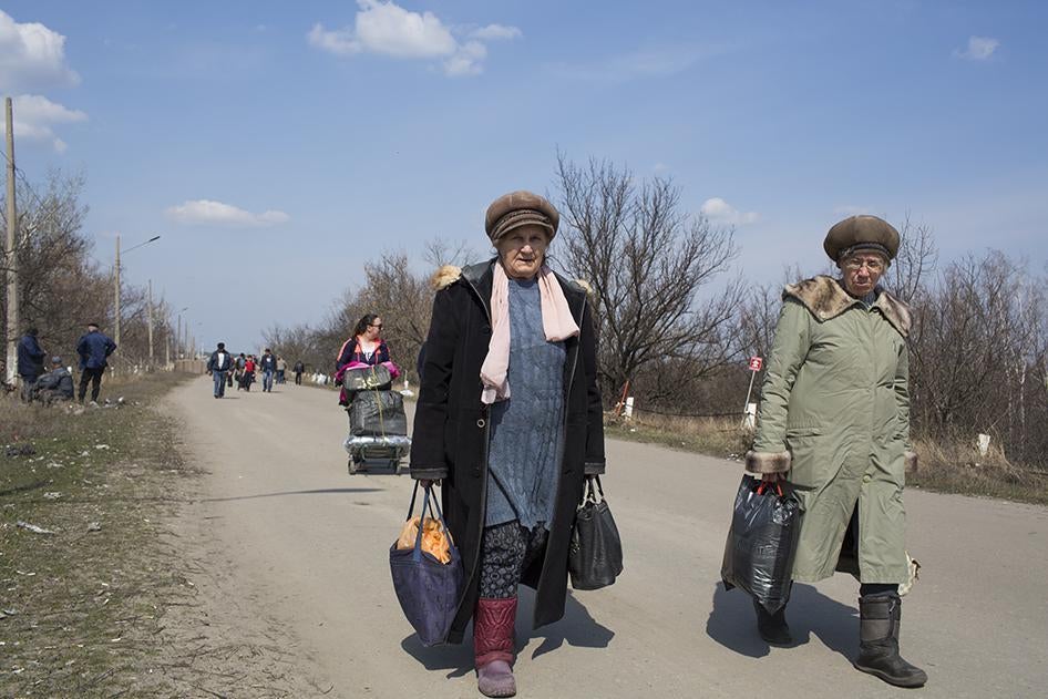 People walking across the crossing point at Stanitsa Luhanska. 