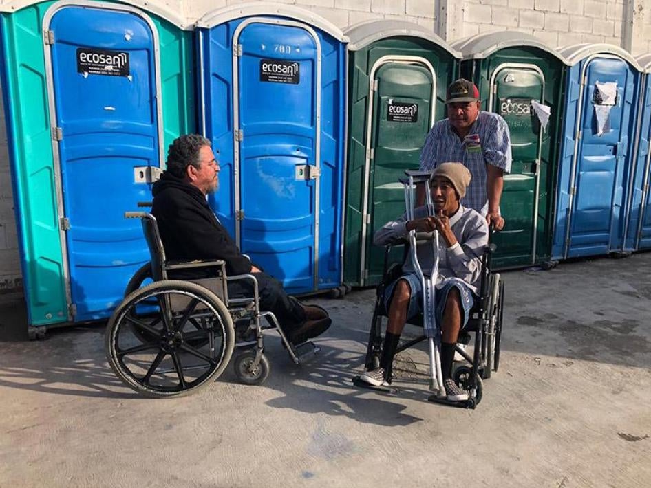 Un migrant hondurien (à droite) s’entretient avec un chercheur de Human Rights Watch (à gauche), sur les difficultés supplémentaires auxquelles sont confrontées les personnes handicapées – comme pour l’utilisation des toilettes - dans un centre situé à El