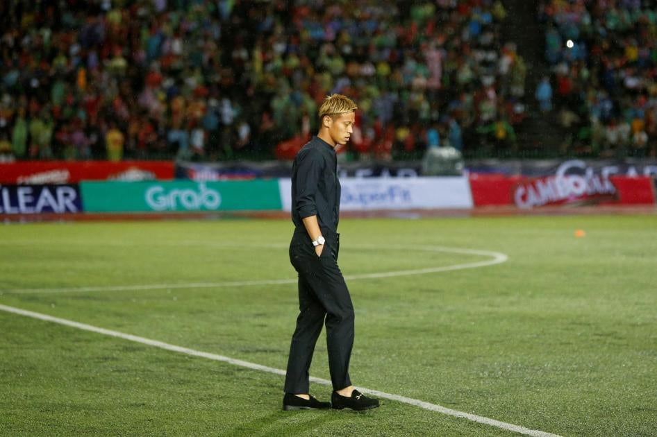Former Japan football player Keisuke Honda walks on the pitch during his debut as coach of Cambodia's national football team at a friendly match against Malaysia, in Phnom Penh, Cambodia, September 10, 2018. 