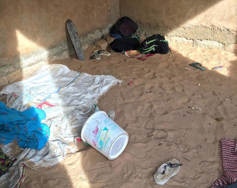 In this traditional Quranic school (daara) in Louga, Senegal, a begging bowl, tablets with Quranic verses, and scattered blankets fill the room where talibé children sleep at night, on the sand, without protection from malaria-carrying mosquitos.