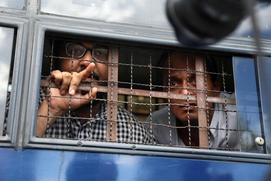 Myanmar journalist Aung Naing Soe (left) and driver Hla Tin look out from a prison transport vehicle after being sentenced by a court in Naypyidaw, November 10, 2017.