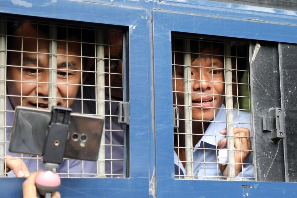 Journalists Aye Nai (left) and Lawi Weng speak to reporters from inside a prison transport vehicle outside the courthouse in Hsipaw, Shan State, July 28, 2017. 