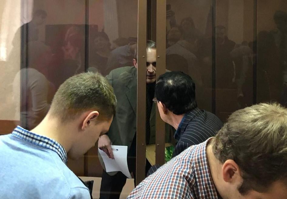 Dennis Christensen, citoyen danois et adepte des Témoins de Jéhovah (derrière la vitre), parle avec son interprète au Tribunal du District de Zheleznodorzhy à Orel, en Russie, le 28 janvier 2019.