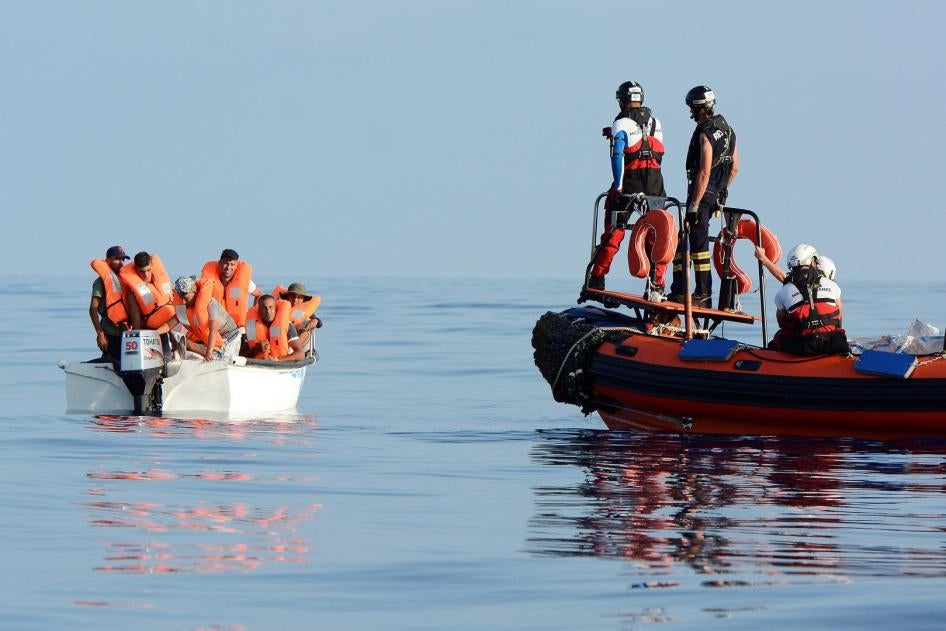 Des migrants sont vus à bord d’un bateau en fibre de verre en Méditerranée, au large des côtes libyennes, le 12 août 2018. 