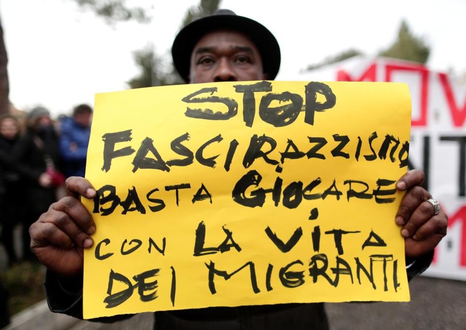 A demonstrator holds a banner reading "Stop fascism and racism: stop playing with migrants' life" during an anti-racism rally in Macerata, Italy, February 10, 2018.
