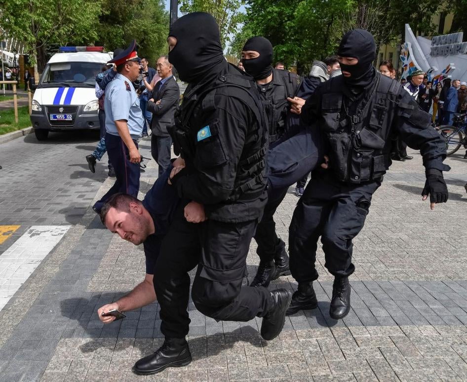Masked law enforcement officers detain protester at a May 10 rally in Almaty, Kazakhstan. 