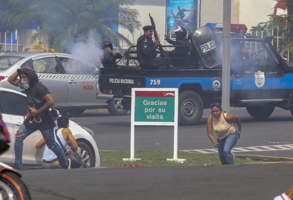 Un oficial de la Policía Nacional dispara a un grupo de personas afuera del centro comercial Metrocentro en Managua, Nicaragua, 28 de mayo de 2018.