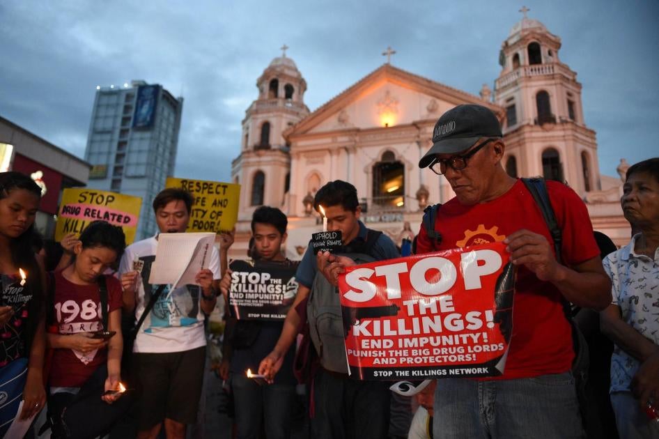 Activists hold a candle light vigil for victims of the extra judicial killings in the drug war of the government in front of a church in Manila on September 16, 2016