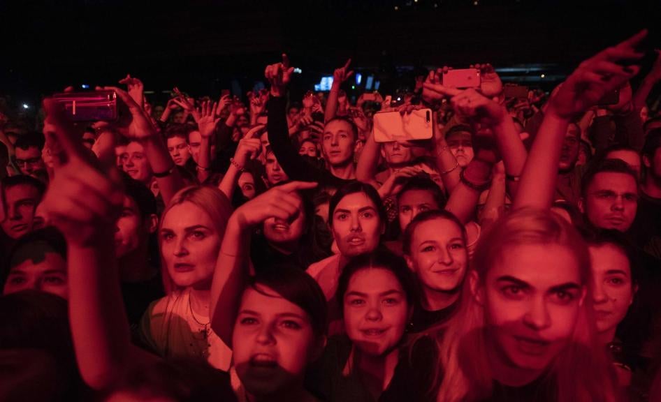 People cheer during a concert in support of rapper Husky, in Moscow in Moscow, Russia. 
