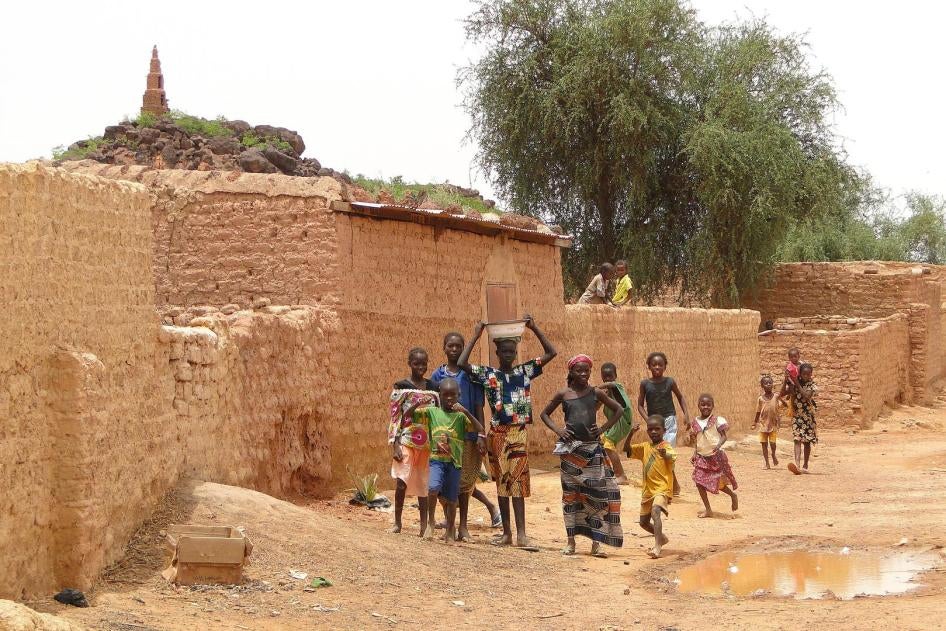 Villagers walk past a Mosque in the Sahel Region, in 2010. Tens of thousands of civilians have been forced to flee their homes as a result of the growing violence in northern Burkina Faso. 