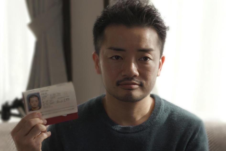 Fumino Sugiyama, un hombre transgénero, sostiene su tarjeta de identificación japonesa, que dice "mujer", en su casa en Tokio.
