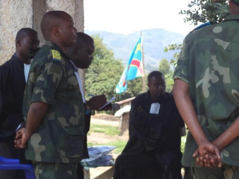 Marcel Habarugira (à gauche, en uniforme militaire) est jugé dans le village de Bweremana, province du Nord-Kivu, République démocratique du Congo, le 15 décembre 2018. 