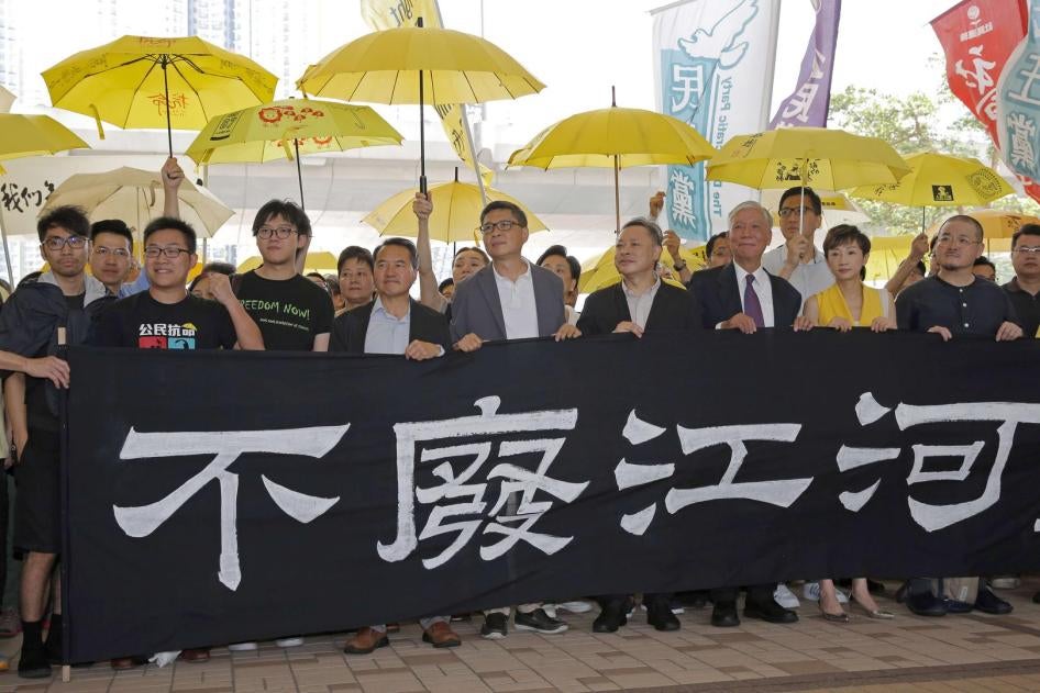 Umbrella Movement leaders hold a banner before entering court in Hong Kong, April 24, 2019.