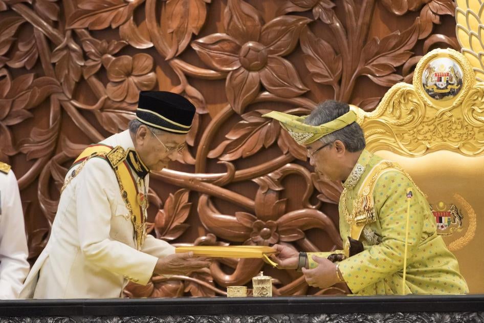 Malaysia's Prime Minister Mahathir Mohamad, left, passes the opening speech to King Sultan Abdullah Sultan Ahmad Shah during the opening of the 14th parliament session at the Parliament House in Kuala Lumpur, Malaysia, Monday, March 11, 2019. 