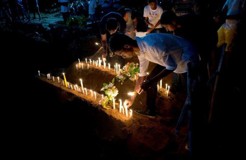 Des proches de victimes de l'explosion d'une bombe le 21 avril 2019 – dimanche de Pâques – dans l'église Saint-Sébastien de Negombo, au Sri Lanka, allument des bougies parmi les décombres de l’eglise au lendemain de cet attentat meurtrier.