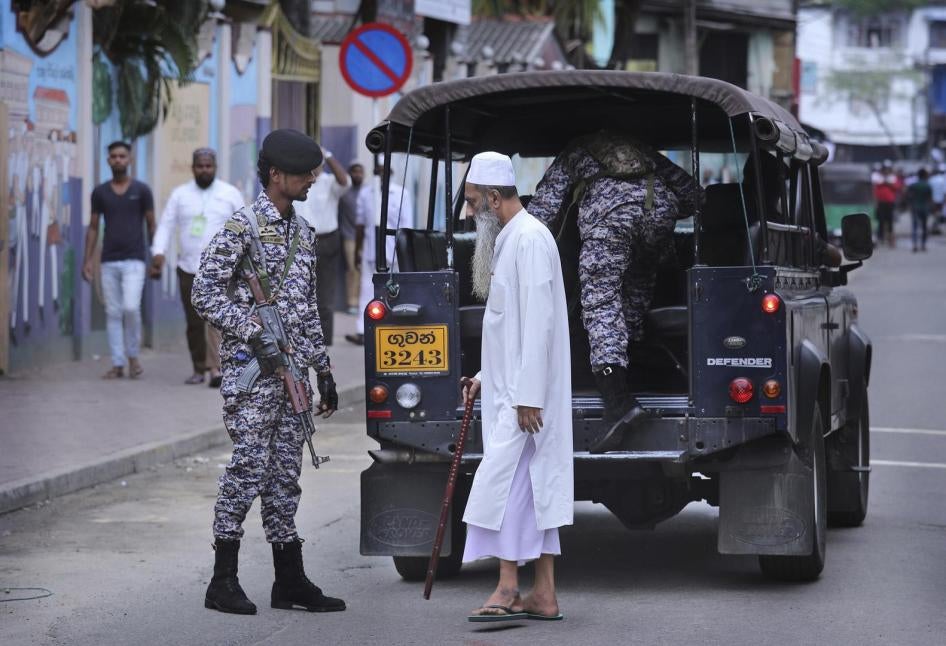 A Sri Lankan Muslim walks past patrolling army soldiers in Colombo, Sri Lanka, Friday, April 26, 2019.