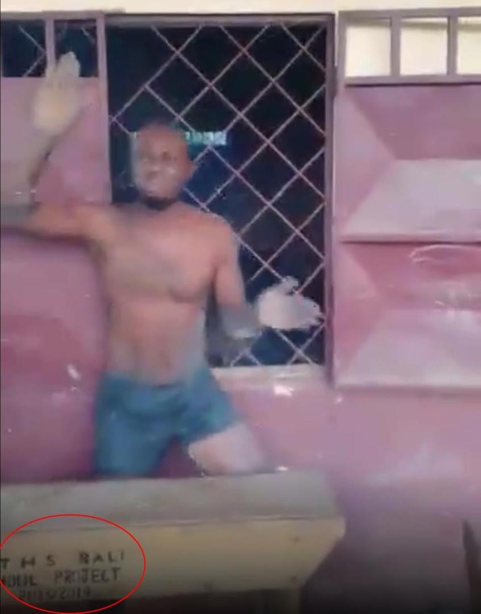 Capture d’écran d'une vidéo montrant un homme qui aurait été torturé par des séparatistes au Cameroun, à 05:41. Des inscriptions apparaissant sur un bureau semblent indiquer que la vidéo a été filmée à l’École technique secondaire publique de Bali, dans l