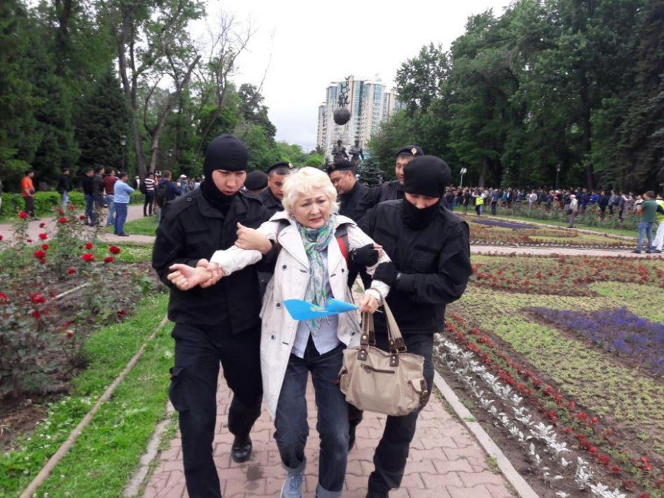 Deux membres des forces de l'ordre kazakhes emmenent une femme ayant participé à une manifestation pacifique à Almaty, le 9 juin 2019, lors de l’élection présidentielle.