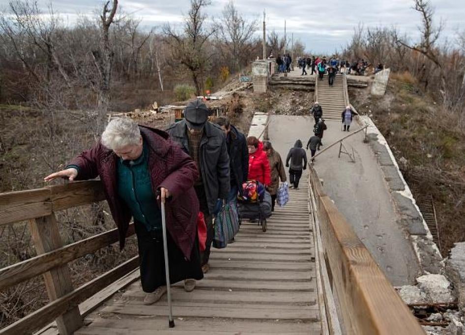 Літні люди йдуть по зруйнованому мосту на контрольному пункті в’їзду-виїзду (КПВВ) «Станиця Луганська». 6 листопада 2018 року. 