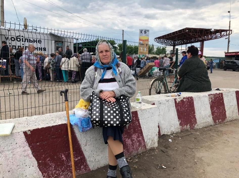 Galina, a 78-year-old pensioner, sitting near the Stanytsia Luhanska checkpoint in eastern Ukraine.