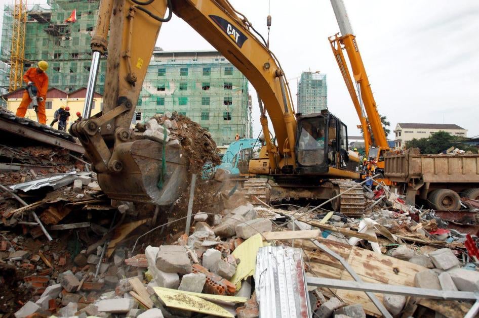 An excavator removes the rubble at the site of a collapsed building in Preah Sihanouk province, Cambodia, Saturday, June 22, 2019.