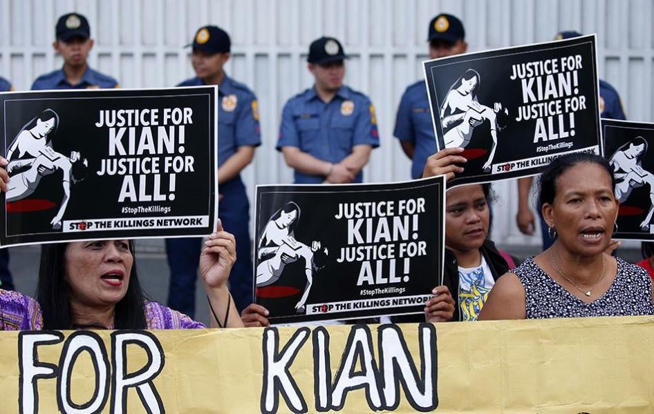 示威人士在菲律宾国家警察总部门外举牌、呼口号，抗议警方杀害17岁高二学生基恩・桑托斯，摄于菲律宾马尼拉，2017年8月23日。