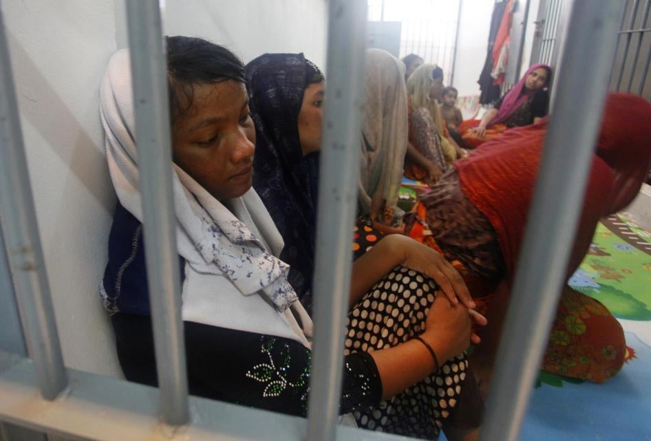 Rohingya refugees sit behind bars at a police station in Satun province, Thailand, June 12, 2019.