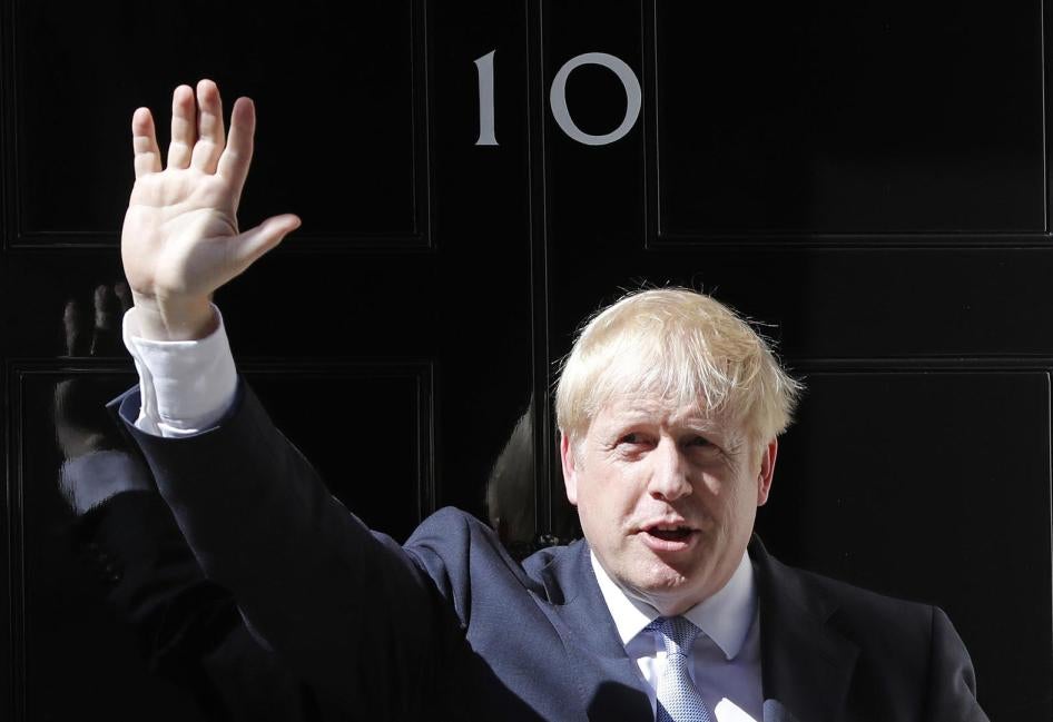 英国新任首相约翰逊在唐宁街10号官邸门口挥手致意，2019年7月24日摄于伦敦。