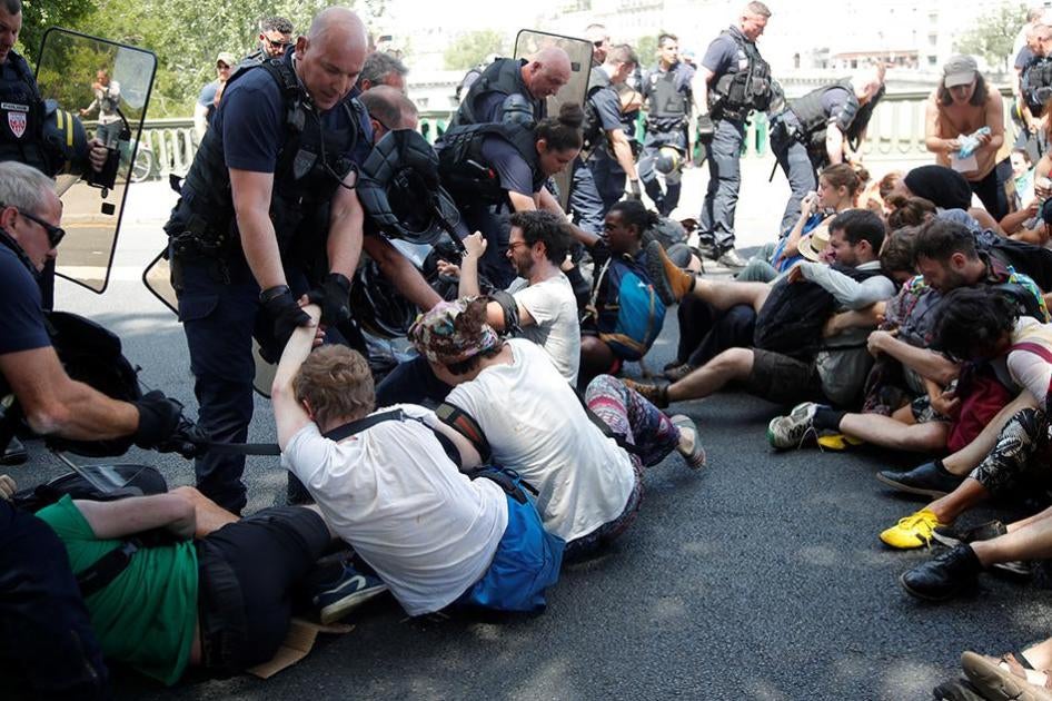 French CRS riot police forcibly remove French youth and environmental activists as they block a bridge during a demonstration in Paris, France.