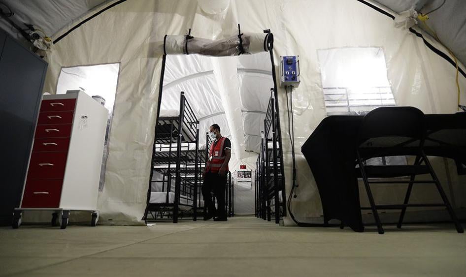 A staff member works in the infirmary, a series of tents, at a US government immigration holding center in Carrizo Springs, Texas