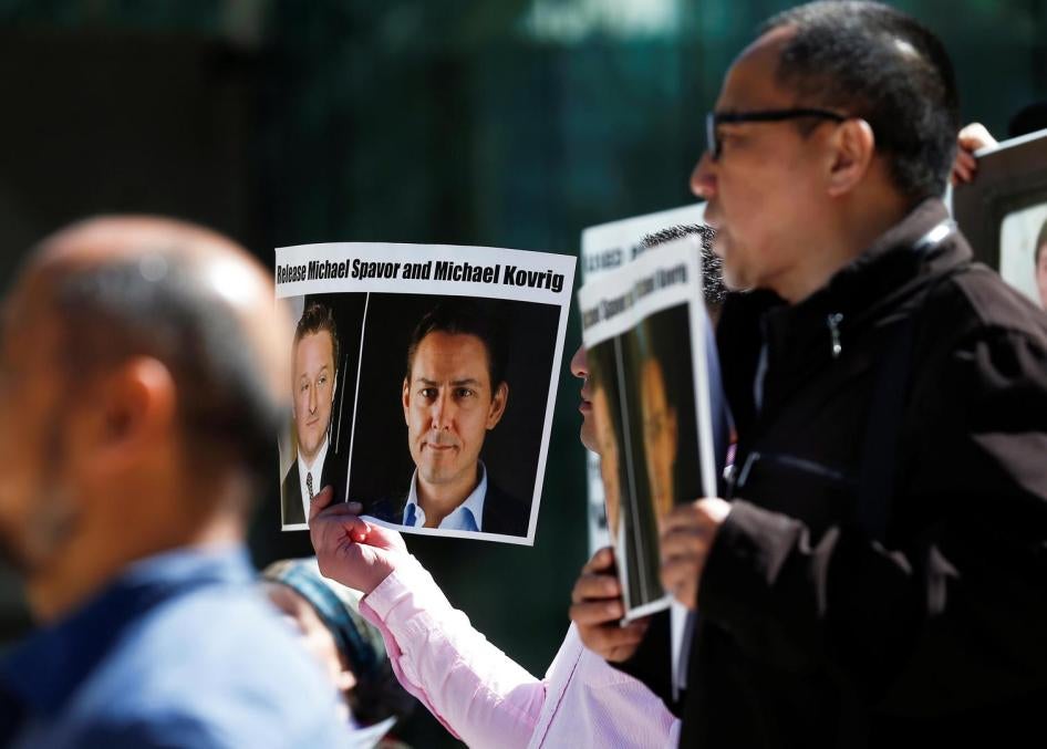 People hold signs calling for China to release Canadian detainees Michael Spavor and Michael Kovrig during a court appearance by Huawei's Financial Chief Meng Wanzhou, outside of British Columbia Supreme Court building in Vancouver, British Columbia