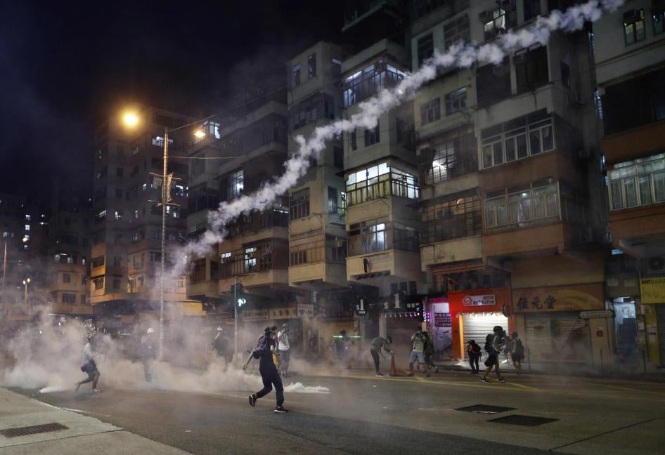 Protesters react to teargas from the Sham Shui Po police station in Hong Kong, August 14, 2019.