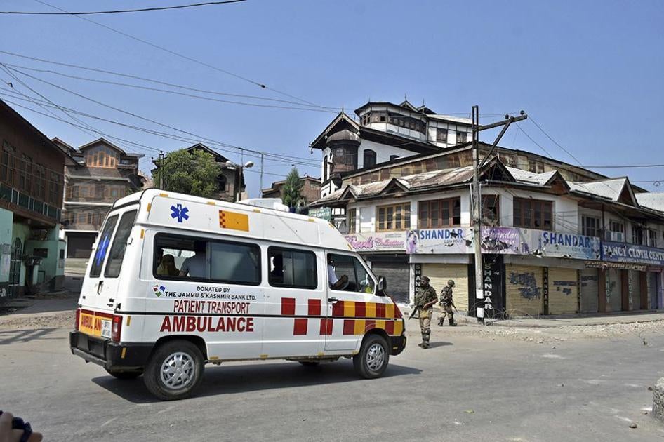 A paramilitary trooper stops an ambulance during the curfew in Srinagar.