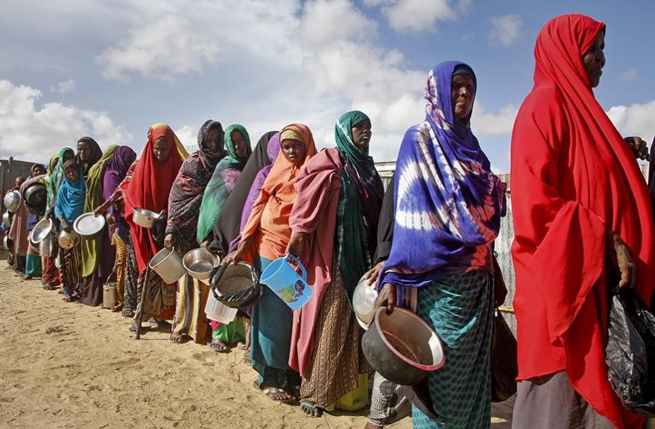 Women who fled drought line up to receive food distributed by local volunteers at a camp for displaced persons in the Daynile neighborhood on the outskirts of the Somalian capital Mogadishu