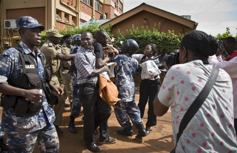Media and members of Uganda's Human Rights Network for Journalists struggle with police as they protest outside the Daily Monitor newspaper head office