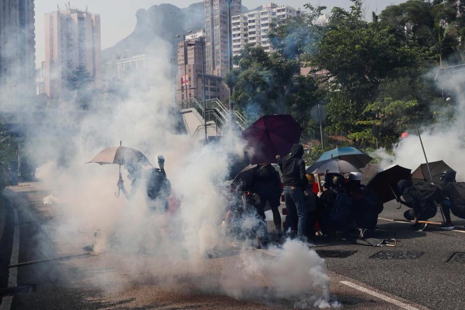 Protesters react from tear gas during a demonstration on China's National Day, under Lion Rock Hill, in Wong Tai Sin, Hong Kong, China October 1, 2019. 