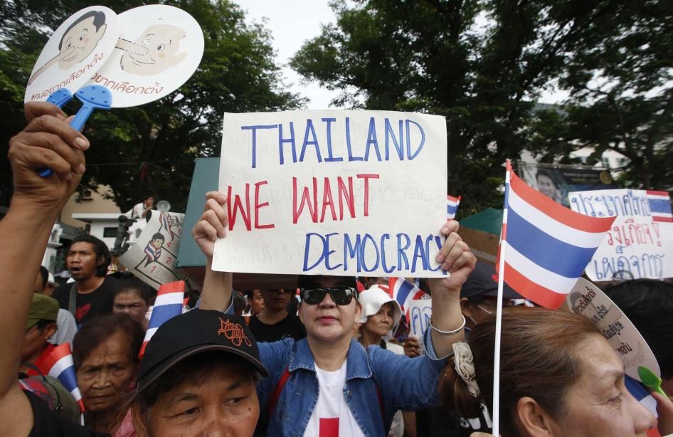 Le 22 mai 2018, à l’occasion du quatrième anniversaire du coup d'État militaire en Thaïlande, une manifestante à Bangkok brandit une pancarte avec le message : « Nous voulons la démocratie » .